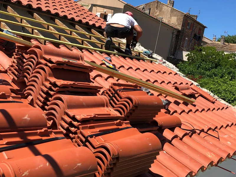Artisan de Uhlmann P. Rénovation posant des tuiles sur une toiture