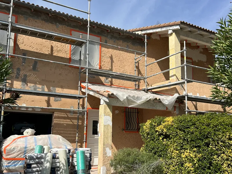 Façade en cours de préparation sous échafaudage avant enduit
