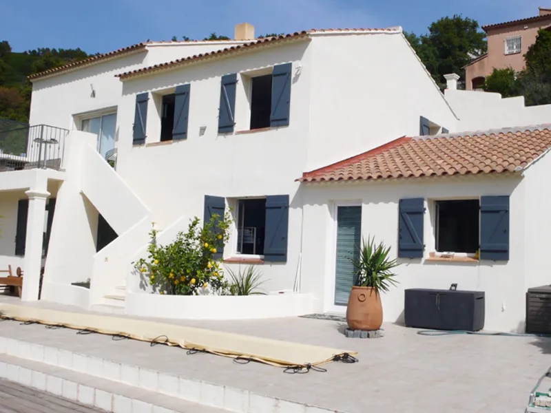 Villa méditerranéenne rénovée avec façade blanche et volets bleus